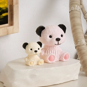 Detail of pink and white resin bears with woven texture on a white stone base