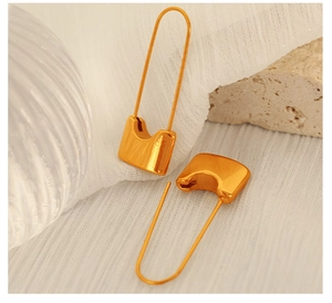 Close-up of golden paperclip earrings on stone base featuring minimalist metal design