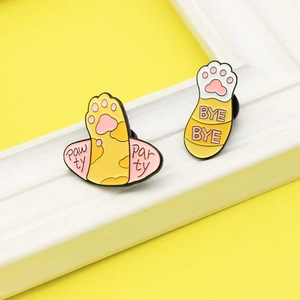 Detail of colorful enamel cat paw pins with Pawty Party and Bye Bye text designs