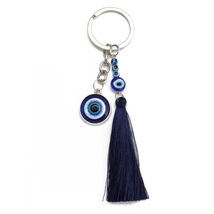Detail of the blue evil eye keychain featuring long silk tassels and beaded charms