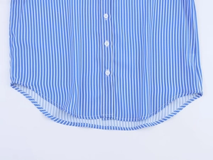 Detail of blue and white striped shirt showing vertical patterns and white resin buttons