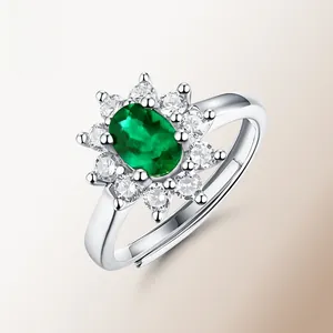 Detail of emerald green oval stone ring with halo setting and adjustable silver band