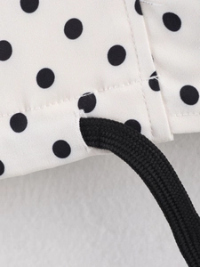 Dettaglio della giacca retrò francese a pois con coulisse nera intrecciata e cuciture fini