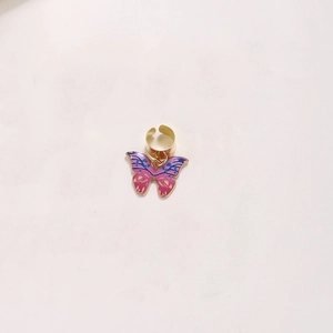 Close-up of golden adjustable hair ring with pink and blue butterfly enamel pendant