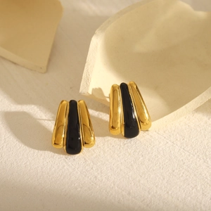 Macro view of vintage gold stud earrings with black enamel drip oil finish and 18k plating
