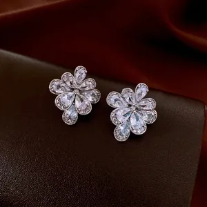 Elegant silver flower stud earrings with water drop cubic zirconia on velvet background