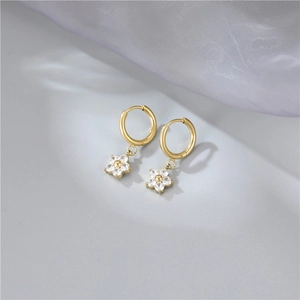 Elegant gold flower hoop earrings with white zircon crystals on grey silk background