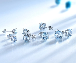 Vue détaillée de puces d'oreilles en argent S925 avec pierres d'émeraude bleu clair