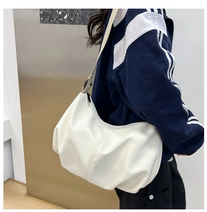 White pleated hobo bag shown on shoulder highlighting the soft PU leather and slouchy shape