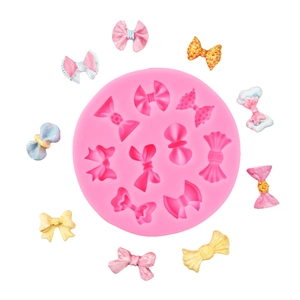 Detail of pink silicone mold with assorted fondant bows in blue, yellow and gold colors