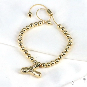 Close-up of golden beaded bracelet with rhinestone letter Y and adjustable clasp