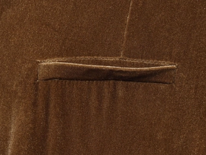 Gros plan sur la texture du velours marron et le détail de la poche d'un costume chic
