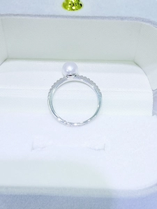 Close-up of a 6-7mm white freshwater pearl ring set in silver with sparkling pavé accents