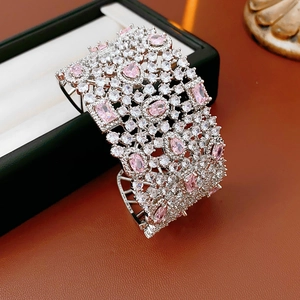 Close-up of sparkling wide cuff bracelet with pink zircon stones and pave-set crystals