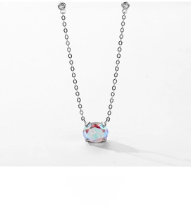 Macro shot of minimalist silver necklace featuring a four-prong set iridescent round gem