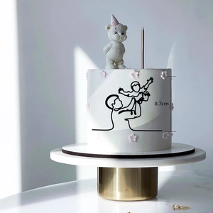 Minimalist black acrylic cake topper featuring a parent lifting a child, 8.7cm height
