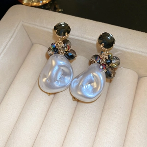 Close-up of Baroque pearl earrings with crystal beads and gold-tone metal details