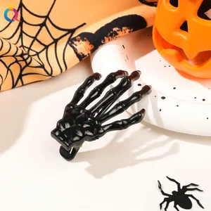 Close-up of black skeleton bone hair clip with pumpkins and spooky Halloween decor