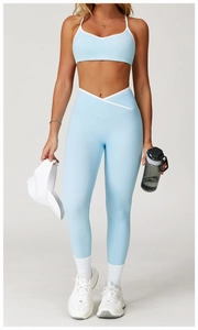 Detail van lichtblauwe yoga-legging met hoge taille en witte V-vormige crossover-band