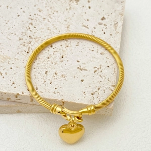 Golden twisted cable bracelet with a polished heart pendant and secure hook closure