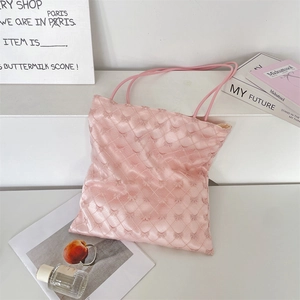 Detail of pink quilted tote bag with bow accents and ribbon textures in a studio setting