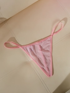 Vue détaillée d'un string en maille rose avec bords élastiques et étiquette de taille M