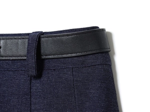 Dettaglio della trama del tessuto a pieghe blu scuro con cintura in pelle nera