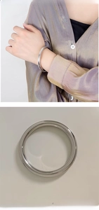 Polished silver stainless steel hollow bangle shown on wrist and as a single item
