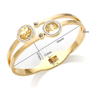 Detailed close-up of gold stainless steel tree of life bangle with white zircon inlays