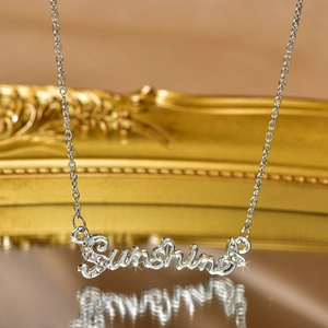 Macro shot of silver Sunshine pendant necklace with sparkling gems and mirror reflection