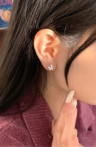 Close-up of zircon butterfly stud earring on ear with silver finish and shiny stones