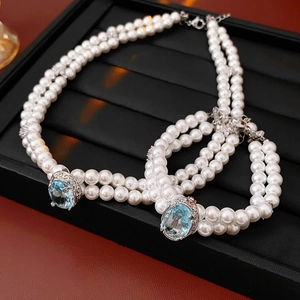 Détail d'un collier de perles double couche et d'un bracelet avec fermoirs en pierre bleue
