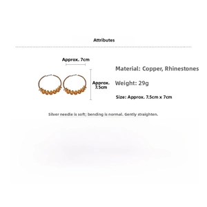Détail de grandes boucles d'oreilles rondes avec strass ambrés en poire et tiges en argent