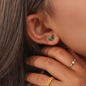 Close-up of elegant gold ring with green marquise zircon and sparkling pavé accents
