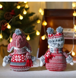 Gros plan de bonhommes de neige de Noël tricotés avec détails en peluche et décor festif
