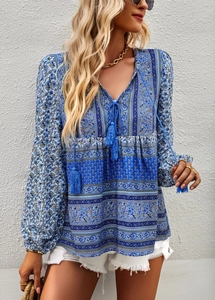 Detail of Bohemian floral print blouse with V-neckline and decorative tassel necktie