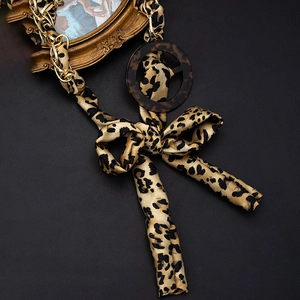 Fashionable leopard print waist belt with golden metal chains and elegant ribbon bow