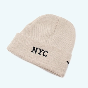 Detail of beige knitted beanie featuring black NYC embroidery and high-quality ribbed texture
