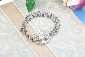 Detailed close-up of a silver double-layer tree of life pendant bracelet on a gift box