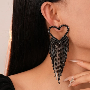 Detailed close-up of long black rhinestone heart tassel earrings worn by a model