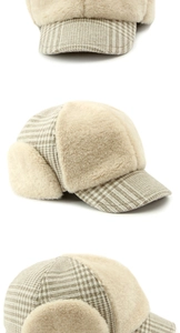 Detail view of winter earflap hat with cream plush lining and brown plaid fabric