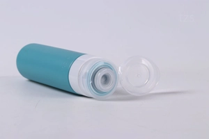 Close-up of a blue 100ml silicone travel bottle with an open white flip cap