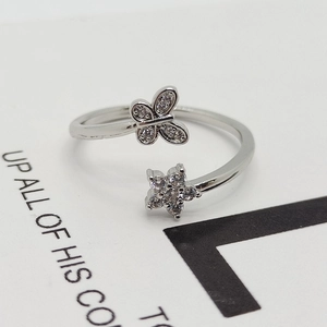 Detail view of silver zircon butterfly and flower ring with sparkling micro-pave crystals
