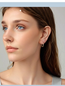 Close-up of elegant gold starry hoop earrings worn on a model for a minimal luxury look