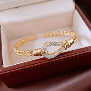 Close-up of 18K gold plated teardrop bracelet with horseshoe buckle in a gift box