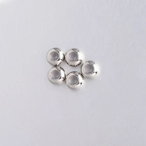Close-up of five 8mm polished stainless steel stopper beads with rubber core for DIY jewelry