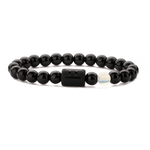 Makro-Detail des elastischen Sternzeichen-Armbands mit Onyxperlen und Zwillinge-Symbol