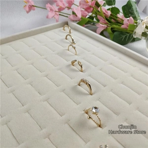 Detail of assorted gold-plated rings with white zircons on a beige velvet jewelry tray