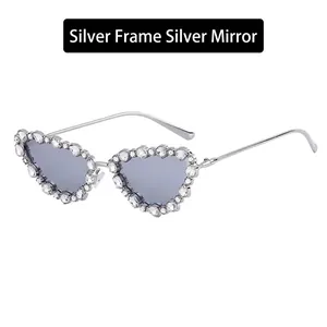 Detail of heart-shaped silver metal sunglasses with rhinestones and silver mirror lenses