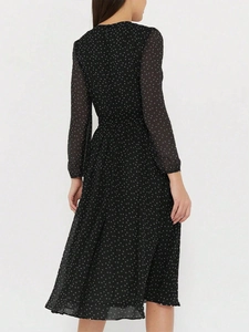 Vue arrière d'une robe noire à pois à manches longues montrant la taille et la jupe